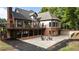 A view of the back of the home, the upper deck and the lower patio with firepit at 6685 Driskell Rd, Cumming, GA 30041