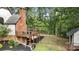 A view of the deck, brick chimney, and shed in the backyard at 6685 Driskell Rd, Cumming, GA 30041