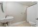Cozy bathroom featuring a pedestal sink, ceramic tile flooring, and a shower and bathtub combo at 6685 Driskell Rd, Cumming, GA 30041
