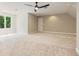 Carpeted bedroom with ceiling fan and large windows overlooking trees provides ample natural light at 6685 Driskell Rd, Cumming, GA 30041