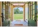 Elegant entryway with stone archway, decorative lighting, and a view of the landscaped front yard at 6685 Driskell Rd, Cumming, GA 30041