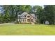 Charming two-story home with a manicured lawn and stone and white siding at 6685 Driskell Rd, Cumming, GA 30041