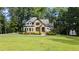 Charming two-story home with a manicured lawn and stone and white siding at 6685 Driskell Rd, Cumming, GA 30041