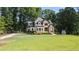 Charming two-story home with a brick facade, complemented by a well-manicured lawn and mature trees at 6685 Driskell Rd, Cumming, GA 30041