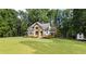 Charming two-story home with a manicured lawn and stone and white siding at 6685 Driskell Rd, Cumming, GA 30041