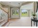 Bright foyer featuring hardwood floors, staircase, and views of the lush backyard through large windows at 6685 Driskell Rd, Cumming, GA 30041
