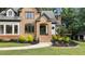 Close up of the stone and siding exterior, arched doorway, and landscaped front yard at 6685 Driskell Rd, Cumming, GA 30041