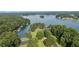 A scenic lake view with lush green trees, a parking lot, and clear blue water at 6685 Driskell Rd, Cumming, GA 30041