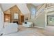 Bright living room with stone fireplace, built-in shelves, and staircase access at 6685 Driskell Rd, Cumming, GA 30041