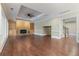 Open-concept living room with hardwood floors, fireplace, built-in shelving and large windows to outside view at 6685 Driskell Rd, Cumming, GA 30041