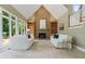 Bright living room features a stone fireplace and large windows offering a scenic outdoor view at 6685 Driskell Rd, Cumming, GA 30041
