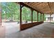 Outdoor patio space complete with a fireplace and seating area surrounded by trees at 6685 Driskell Rd, Cumming, GA 30041