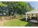 Beautifully landscaped backyard with a covered patio and mature trees at 964 Natural Brook Trl, Lawrenceville, GA 30045