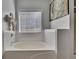 Bright white bathroom featuring a soaking tub and natural light at 964 Natural Brook Trl, Lawrenceville, GA 30045