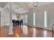 Elegant dining area with hardwood floors, a statement chandelier, and natural light from large windows at 964 Natural Brook Trl, Lawrenceville, GA 30045