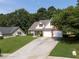 Inviting home featuring a well-kept lawn, spacious driveway, and traditional architectural details at 964 Natural Brook Trl, Lawrenceville, GA 30045