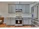 Modern kitchen with gray cabinets, stainless steel appliances, and stylish tiled flooring at 964 Natural Brook Trl, Lawrenceville, GA 30045