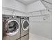 Convenient laundry room with stainless steel washer and dryer and shelving at 964 Natural Brook Trl, Lawrenceville, GA 30045