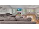 Bright living room with a gray sectional, fireplace, and lots of natural light at 964 Natural Brook Trl, Lawrenceville, GA 30045