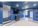 Basement with blue walls, stairs, tv and rug on the concrete floor at 20 Scarlett Oak Ne Dr, Cartersville, GA 30121