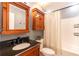 Bathroom features wooden cabinets, black countertop and bathtub with shower at 20 Scarlett Oak Ne Dr, Cartersville, GA 30121