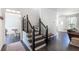 Inviting foyer features dark wood floors, black and white staircase, and views into living spaces at 20 Scarlett Oak Ne Dr, Cartersville, GA 30121
