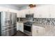 Modern kitchen featuring stainless steel appliances, granite countertops, and mosaic tile backsplash at 20 Scarlett Oak Ne Dr, Cartersville, GA 30121