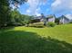Expansive backyard with lush lawn, trees, and a partial view of a charming home at 200 Chaparral Trce, Tyrone, GA 30290