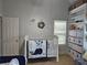 Bedroom with a white crib, ample shelving, and decorative nautical artwork for a serene atmosphere at 200 Chaparral Trce, Tyrone, GA 30290