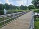 Picturesque wooden bridge over a tranquil pond with a fountain and lush green surroundings at 200 Chaparral Trce, Tyrone, GA 30290