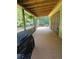 Wide covered wooden porch showcasing a backyard area, offering ample space and relaxing atmosphere at 200 Chaparral Trce, Tyrone, GA 30290