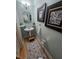 Elegant powder room featuring a pedestal sink, decorative mirror, and stylish wall art with a coastal theme at 200 Chaparral Trce, Tyrone, GA 30290