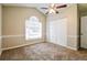 This bedroom offers neutral walls, plush carpet, a ceiling fan, and a window allowing plenty of natural light at 3163 Springside Xing, Decatur, GA 30034
