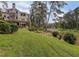 Backyard view of the two story home with a balcony, lake, lush green grass and trees at 1530 Niskey Lake Sw Trl, Atlanta, GA 30331