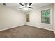 Neutral bedroom with carpet, two windows with a view of the trees, and a ceiling fan at 2004 Township Dr, Woodstock, GA 30189