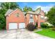 Charming two-story brick home with a two car garage and well-manicured landscaping at 2004 Township Dr, Woodstock, GA 30189
