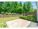 Manicured backyard featuring a paved patio area and privacy fence surrounded by lush landscaping at 3541 Ashcroft Se Dr, Smyrna, GA 30080