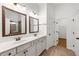 Bright bathroom featuring double vanity, framed mirrors, and a doorway to a walk-in closet at 3541 Ashcroft Se Dr, Smyrna, GA 30080