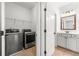 Convenient laundry room featuring front-load washer and dryer adjacent to the bathroom at 3541 Ashcroft Se Dr, Smyrna, GA 30080
