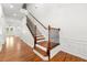 Bright foyer with hardwood floors, a staircase with wood and iron railings, and white trim at 3541 Ashcroft Se Dr, Smyrna, GA 30080