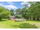 Exterior backyard view of home, above-ground pool, green grass, trees, and a wood deck at 4411 Westerling Ct, Powder Springs, GA 30127