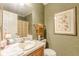 Bathroom with framed floral art, towels, and a wooden vanity with a white sink at 4411 Westerling Ct, Powder Springs, GA 30127