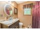 Bathroom with vanity, dark wood cabinets and a red floral patterned shower curtain at 4411 Westerling Ct, Powder Springs, GA 30127
