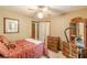 Comfortable bedroom featuring neutral walls, ceiling fan, and matching wood dresser and headboard at 4411 Westerling Ct, Powder Springs, GA 30127