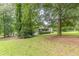 Exterior view of a home featuring a covered porch, a spacious lawn, and mature trees offering shade at 4411 Westerling Ct, Powder Springs, GA 30127
