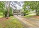 Beautiful exterior view of a home featuring a two-car garage, lovely greenery, and a spacious driveway at 4411 Westerling Ct, Powder Springs, GA 30127