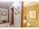Neutral hallway with framed art and a door that leads into a bathroom with wood cabinets and green walls at 4411 Westerling Ct, Powder Springs, GA 30127