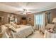 Bedroom featuring a ceiling fan, striped walls, dark furniture and a large decorative bed at 4411 Westerling Ct, Powder Springs, GA 30127