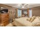 Bedroom featuring a ceiling fan, striped walls, dark furniture and a large decorative bed at 4411 Westerling Ct, Powder Springs, GA 30127