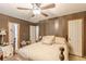 Bedroom featuring a ceiling fan, striped walls, dark furniture and a large decorative bed at 4411 Westerling Ct, Powder Springs, GA 30127
